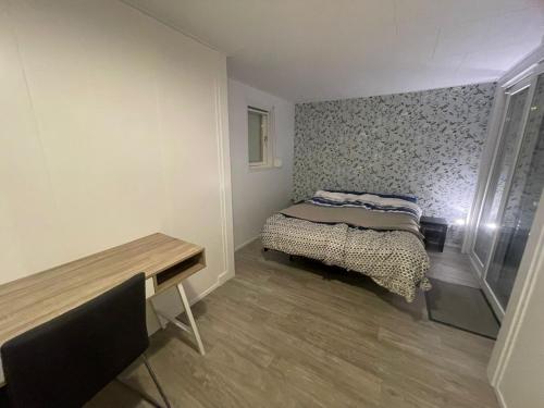 a small bedroom with a bed and a table at Chalet in natuurlijke omgeving in Heel