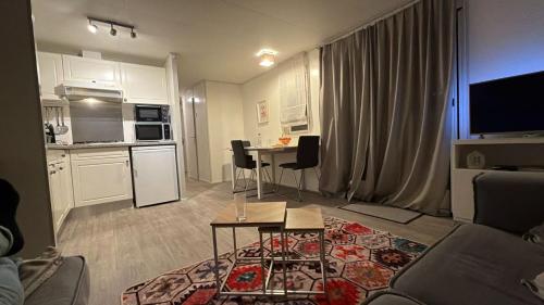 a living room with a couch and a table and a kitchen at Chalet in natuurlijke omgeving in Heel