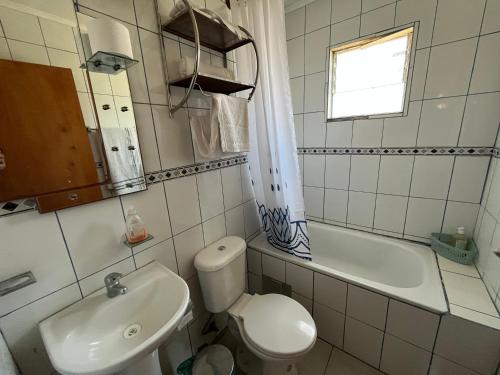 a bathroom with a toilet and a sink and a tub at Cabañas Sra Mery in Quilimarí