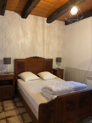 a bedroom with a bed with two night stands and two lamps at La petite maison in Rimaucourt