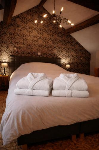 a bedroom with a bed with towels on it at Label Semois-L'Orée des sens-Bain nordique privé in Bouillon