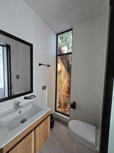 a bathroom with a white sink and a window at El Ensueño - Rest House in La Mesa