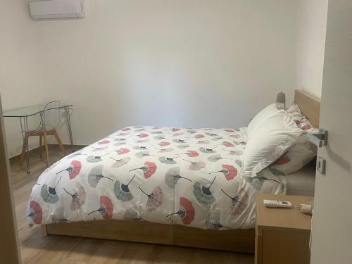 a bedroom with a bed with a comforter and a table at Residenza Sant'Angelo Appartamento ampio con Giardino vicino al Mare in Citta' Sant'Angelo