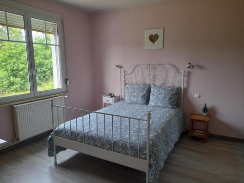 a bedroom with a metal bed with blue pillows at Chambre d'hôtes dans un écrin de verdure in Dambach