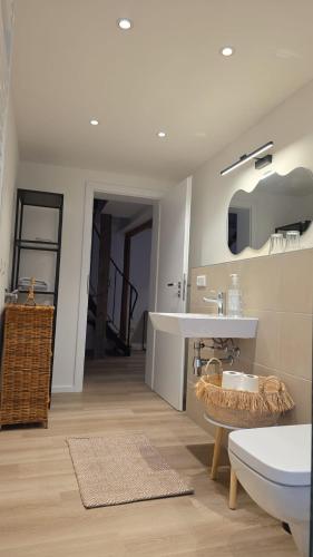 a white bathroom with a sink and a tub at Hof Busen Malibu in Mönchengladbach