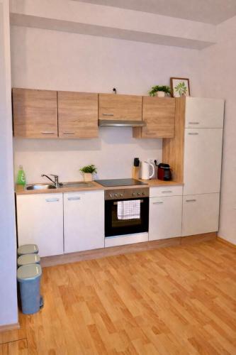 a kitchen with white cabinets and a black oven at Rohrbach Apartments in Ternitz