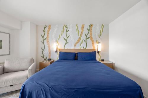 a bedroom with a blue bed and a couch at Luxury Ala Moana Resort 25th floor with balcony in Honolulu