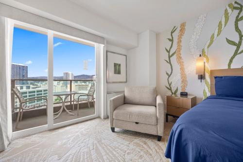 a bedroom with a bed and a chair and a balcony at Luxury Ala Moana Resort 25th floor with balcony in Honolulu