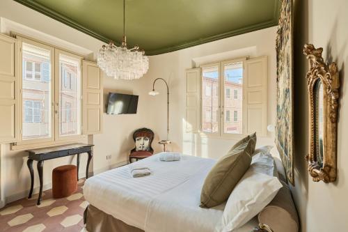 a bedroom with a bed and a table and windows at Boutique Apartment nel Borgo - Casa Olga e Casa Ilde - Le Dimore del centro in Santarcangelo di Romagna