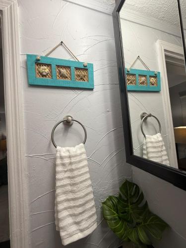 a mirror and towels on a wall in a bathroom at Relaxing 1BR Apartment in Ormond Beach Large Patio in Ormond Beach