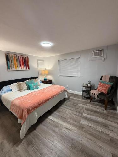 a bedroom with a large bed and a chair at Relaxing 1BR Apartment in Ormond Beach Large Patio in Ormond Beach