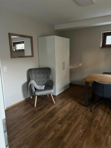 a living room with a chair and a table at Goodie Room I Apartment I Würzburg Estenfeld in Estenfeld