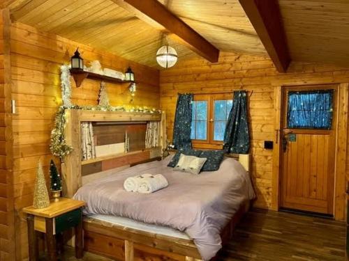 a bedroom with a bed in a log cabin at Fancy Fireflies Cabin in Hayward