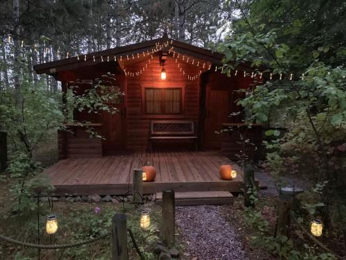 a cabin with pumpkins sitting on a wooden deck at Fancy Fireflies Cabin in Hayward