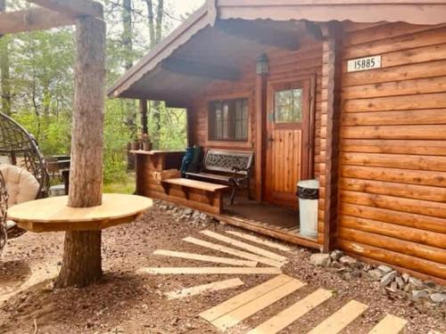 a log cabin with a bench and a table at The Timberjack in Hayward