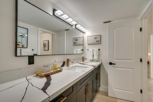a bathroom with two sinks and a large mirror at Waterfront Fort Myers Home Private Pool and Dock in Fort Myers