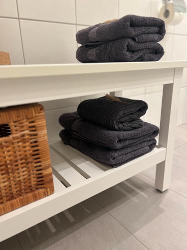 a pile of towels on a shelf in a bathroom at Goodie Room I Apartment I Würzburg Estenfeld in Estenfeld