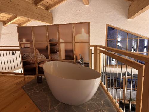 a bathroom with a large bath tub on a balcony at Chalet am Bachl 1 in Flattach