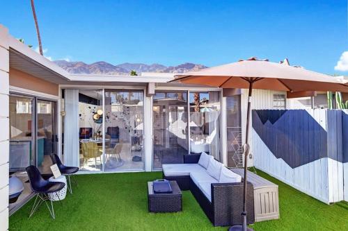a patio with a couch and an umbrella at Ocotillo Art Bungalow in Palm Springs