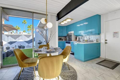 a kitchen with blue cabinets and a table and chairs at Ocotillo Art Bungalow in Palm Springs