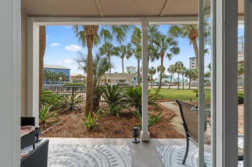 a view from the front porch of a home with palm trees at Grand Caribbean East Poolside Palms in Pensacola