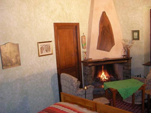 a living room with a fireplace and a chair and a bed at Chalet Su Foxile in Aritzo
