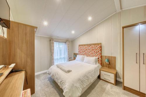 a bedroom with a bed and a dresser and a window at New Forest lodge - 194 NO PETS in Fordingbridge