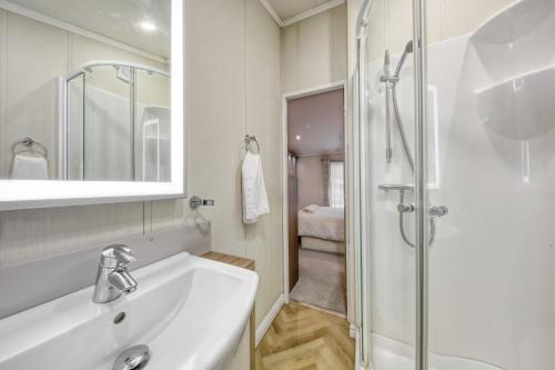 a white bathroom with a sink and a shower at New Forest lodge - 194 NO PETS in Fordingbridge