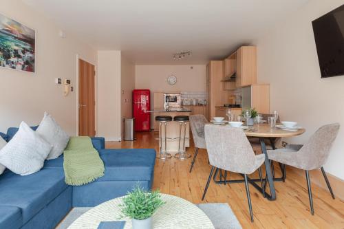 a living room with a blue couch and a table at Modern 2BR Apartments by Luxus Sleeps 6 City Centre in Belfast