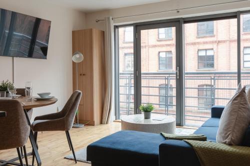a living room with a blue couch and a table at Modern 2BR Apartments by Luxus Sleeps 6 City Centre in Belfast