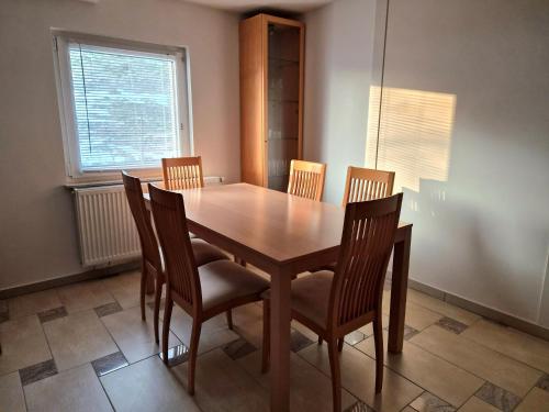 a dining room table with four chairs and a window at Apartment Doroteja in Podplat