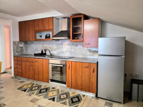 a kitchen with wooden cabinets and a white refrigerator at Apartment Doroteja in Podplat