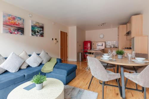 a living room with a blue couch and a table at Modern 2BR Apartments by Luxus Sleeps 6 City Centre in Belfast
