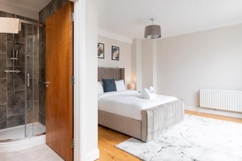 a bedroom with a king sized bed and a shower at Modern 2BR Apartments by Luxus Sleeps 6 City Centre in Belfast