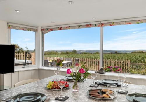 a dining room with a table and a large window at Bwthyn y Ddol - a cottage with stunning views in Cardigan
