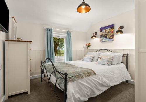 a bedroom with a bed and a window at Bwthyn y Ddol - a cottage with stunning views in Cardigan