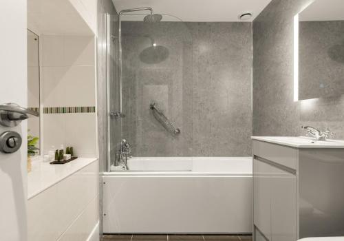 a bathroom with a shower and a tub and a sink at Bwthyn y Ddol - a cottage with stunning views in Cardigan