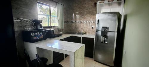 a kitchen with a stainless steel refrigerator and a counter at Arenal Jendrik house in Agua Azul