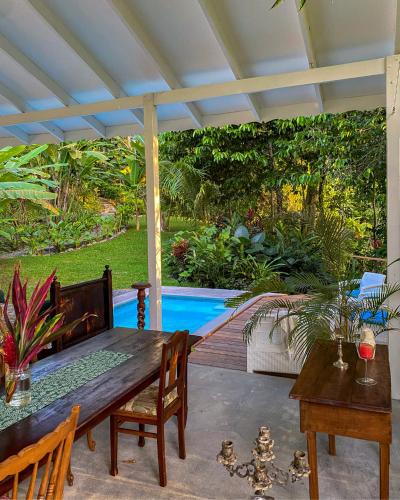 a patio with a table and chairs and a pool at Colina Secreta - Glamping and Villas in Puerto Viejo
