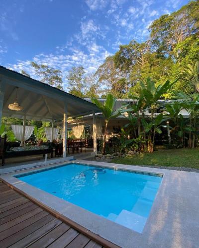 a swimming pool on a deck next to a house at Colina Secreta - Glamping and Villas in Puerto Viejo