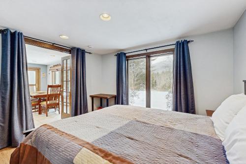 a bedroom with a bed and a table and a window at Peaceful Home in North Conway