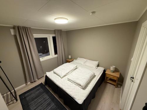 a small bedroom with a bed and a window at Langhaugen - Kabelvåg in Kabelvåg