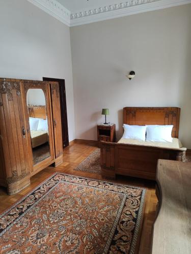una camera da letto con un letto e un grande specchio di Pałac Chojnata a Wola Chojnata