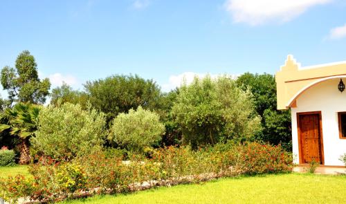 a house with a garden with bushes and trees at Riad Hamdani in Casablanca