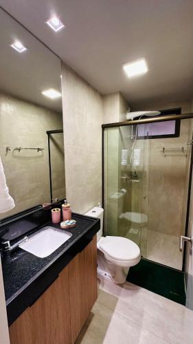 a bathroom with a toilet and a sink and a shower at Brisa Rooftop Vistamar -Apartamento à beira mar com jacuzzi in Luis Correia