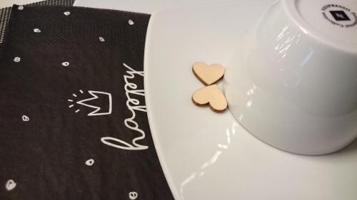 a heart shaped cookie next to a cup of coffee at K82 BNB & Hotel in Kirchentellinsfurt