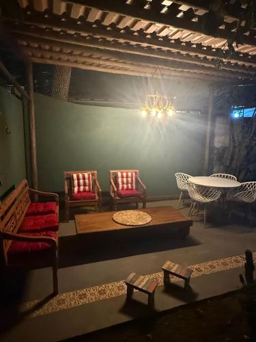 a living room with chairs and a table and a chandelier at Casa Praiana Búzios in Búzios