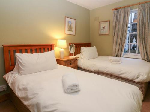 a bedroom with two beds and a window at 1 The Cross in Dunkeld