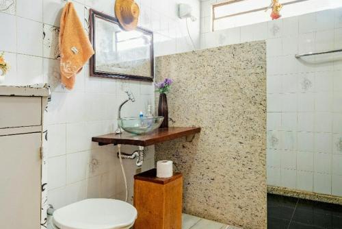 a bathroom with a toilet and a glass bowl on a counter at Suite com ar in Jaú
