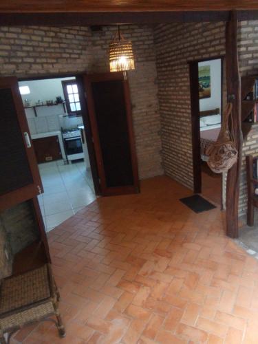 a living room with a tile floor and a chandelier at Pousada Barracuda Pipa in Pipa